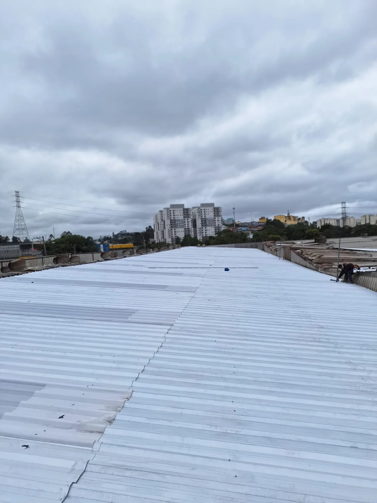 Cobertura industrial renovada com telhas metálicas brancas