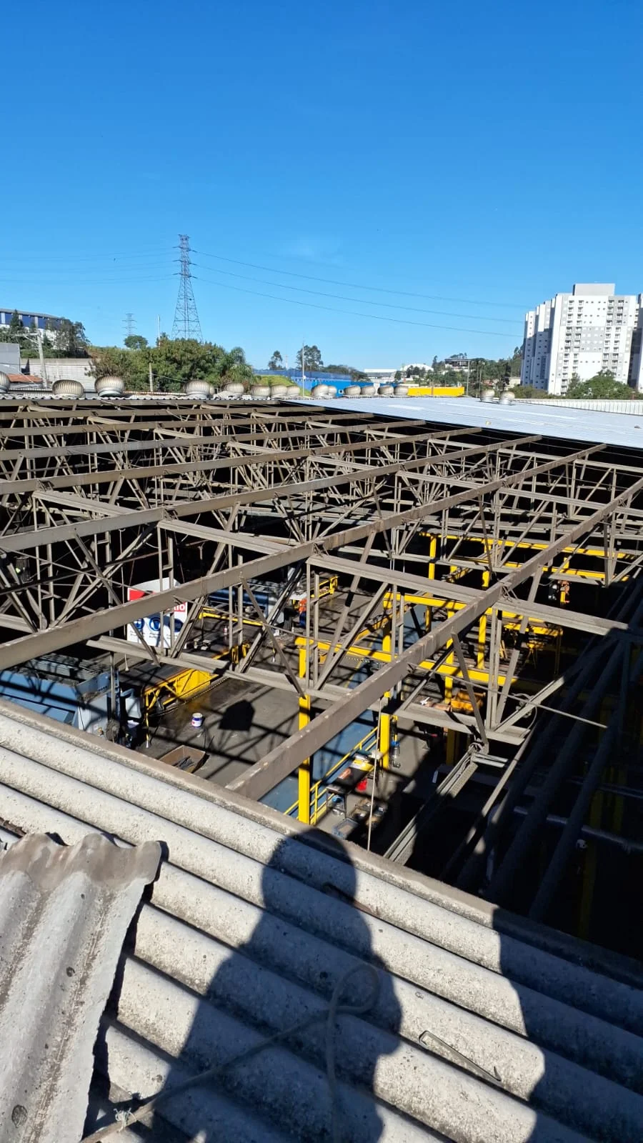 Vista superior de estrutura metálica durante manutenção da cobertura